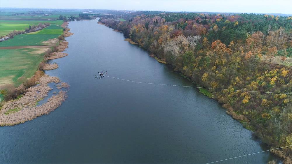 dron rozciągający kabel nad rzeka zastosowanie dronów w energetyce
